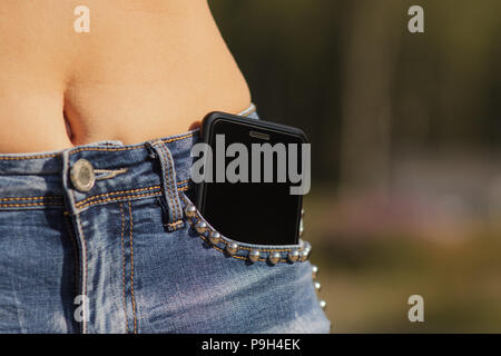 Close-up Portrait of Black smartphone dans une poche avant de girl's jeans Banque D'Images