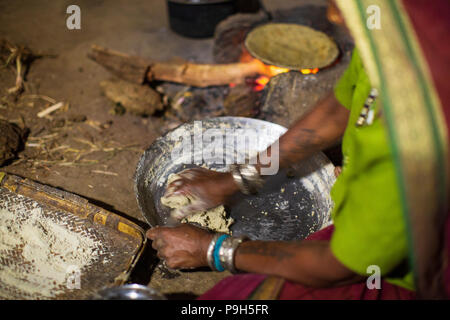 Une femme faisant chantais sur un feu ouvert dans sa cuisine, Sendhwa, Inde. Banque D'Images