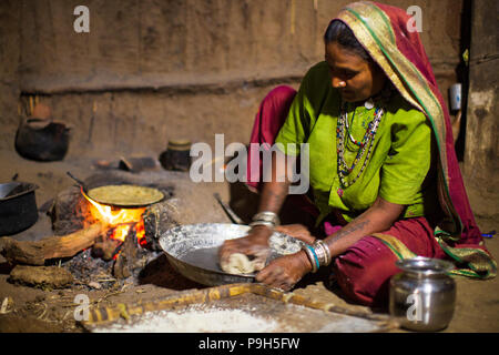 Une femme faisant chantais sur un feu ouvert dans sa cuisine, Sendhwa, Inde. Banque D'Images