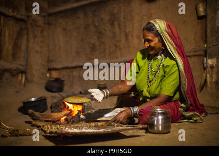 Une femme faisant chantais sur un feu ouvert dans sa cuisine, Sendhwa, Inde. Banque D'Images