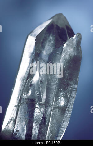 Libre d'un cristal de quartz de Lemurian curatif utilisé pour les pratiques spirituelles et la méditation sur fond bleu foncé Banque D'Images