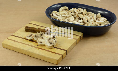 La préparation pour cuire les champignons en coupant sur planche à découper en bois et mettre en bleu plat ingrédient Banque D'Images