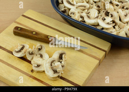 La préparation pour cuire les champignons en coupant sur planche à découper en bois et mettre en bleu plat ingrédient Banque D'Images