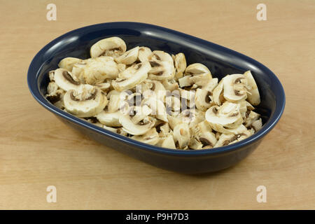 Blanc brut frais haché champignons en bleu foncé plat ovale Banque D'Images