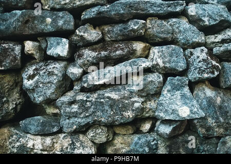 Couleur gris modèle de style moderne décoration design pierre fissurée inégale à la surface du mur avec du ciment. la texture de la pierre couverts de mousse Banque D'Images