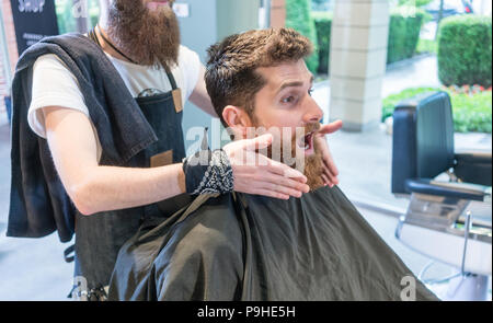 Jeune homme à barbe rousse faisant une grimace avant qu'un changement de look Banque D'Images