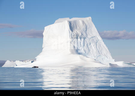 Zodiaques remplir d'énormes icebergs flottent parmi les touristes à Scoresby Sound, Groenland Banque D'Images