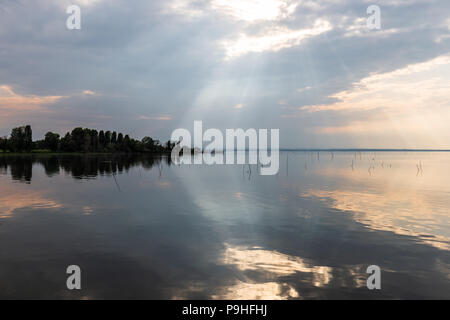 Parfaitement symétrique et vue spectaculaire d'un lac, avec des nuages, le ciel et les rayons du soleil reflétant sur l'eau Banque D'Images