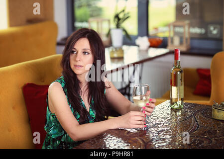 Belle fille goûte le vin dans un restaurant. Banque D'Images