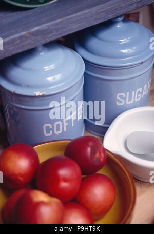 Close-up de boîtes de stockage en émail bleu et le bol de pommes rouges Banque D'Images