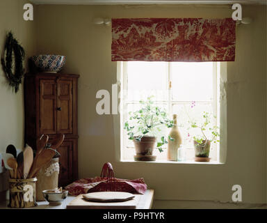 Rose +blanc toile-de-Jouy aveugles sur petite fenêtre en chalet avec cuisine encoignure en pin Banque D'Images