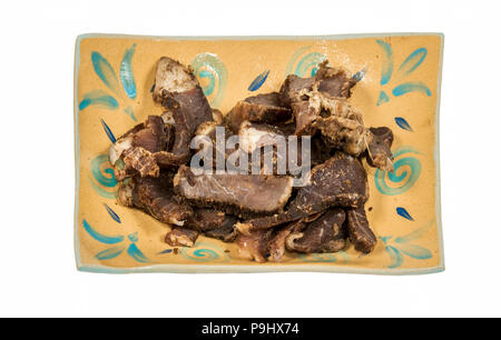 Une assiette de morceaux de viande séchée d'Afrique du Sud - la viande séchée sur fond blanc Banque D'Images