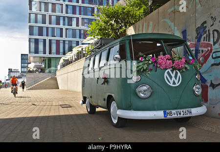 Bremen, Allemagne - Juillet 17th, 2018 Vert - VW T3 van avec grand logo VW blanc avec une façade en verre moderne à l'arrière-plan Banque D'Images