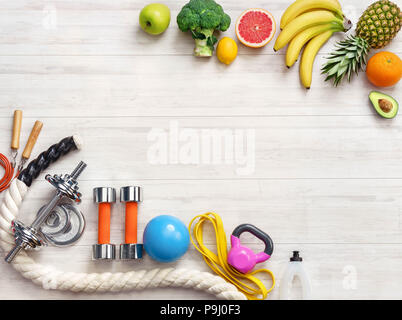 L'équipement de sport et une alimentation saine sur un fond de bois blanc. Vue d'en haut. La motivation. Сopy l'espace. Banque D'Images