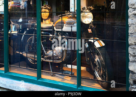 Moto Triumph vintage sur une boutique d'antiquités dans l'affichage des fenêtres Stow on the Wold, Gloucestershire, Cotswolds, en Angleterre. Banque D'Images