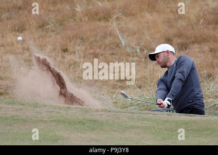 L'Angleterre Tom Lewis plaquettes à partir d'un bunker au 1er au cours de l'aperçu jour 4 de l'Open Championship 2018 à Carnoustie Golf Links, Angus. Banque D'Images