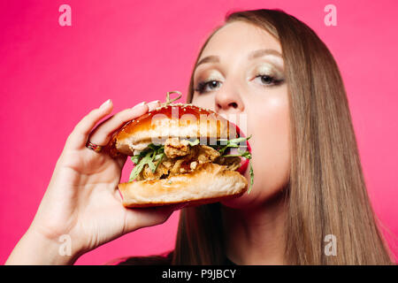 Hungry girl biting burger. Banque D'Images