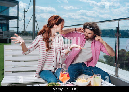 Curly man wearing pink shirt s'amusant avec sa petite amie Banque D'Images