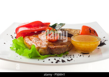 Porc grillé juteux avec des légumes sur un fond blanc, l'isolat Banque D'Images