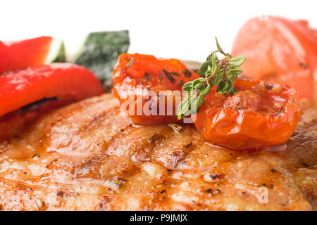 Porc grillé juteux avec des légumes sur un fond blanc, l'isolat Banque D'Images