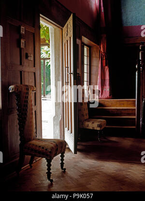 Meubles anciens meubles chaise à côté de porte avant en pays hall avec parquet Banque D'Images