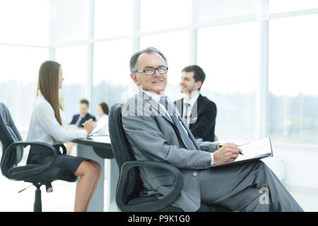 Pensive man in suit avec son équipe travailler derrière Banque D'Images