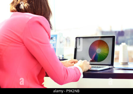 Portrait de l'éditeur de photos avec des couleurs du nuancier working on laptop at desk Banque D'Images