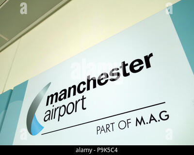 Les passagers devant la publicité sur les murs faisant leur façon de se connecter avec leur vol au Manchester Aéroports Terminal 3 Banque D'Images