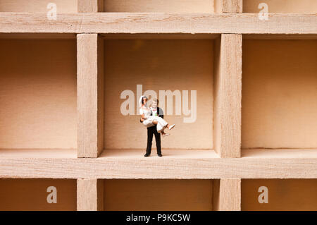 Figurine miniature de groom holding une fiancée, tout concept mariés Banque D'Images