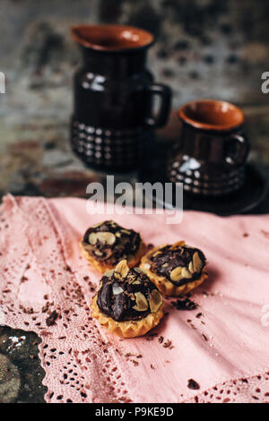 Tartelettes au chocolat saupoudré de remplissage d'amandes. Banque D'Images