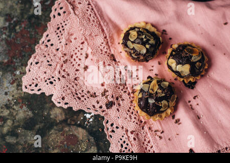 Tartelettes au chocolat saupoudré de remplissage d'amandes. Banque D'Images