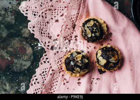 Tartelettes au chocolat saupoudré de remplissage d'amandes. Banque D'Images