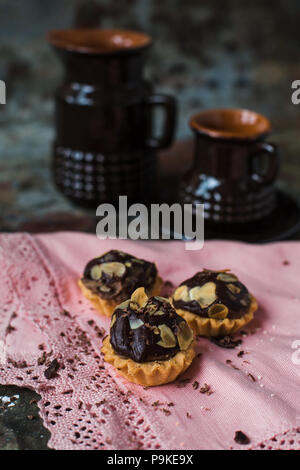 Tartelettes au chocolat saupoudré de remplissage d'amandes. Banque D'Images