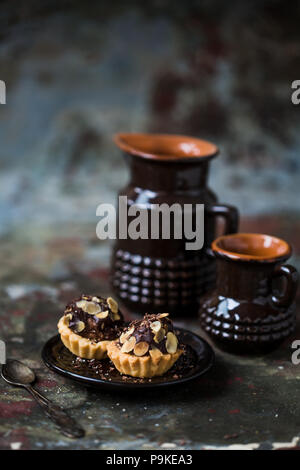 Tartelettes au chocolat saupoudré de remplissage d'amandes. Banque D'Images