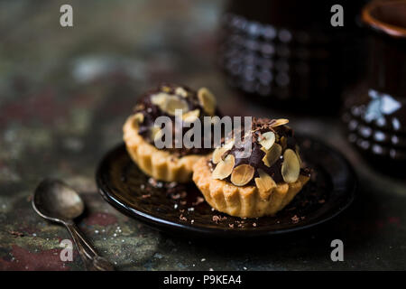 Tartelettes au chocolat saupoudré de remplissage d'amandes. Banque D'Images