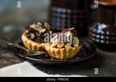 Tartelettes au chocolat saupoudré de remplissage d'amandes. Banque D'Images