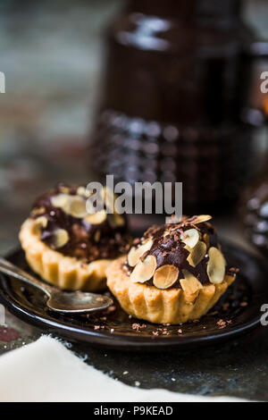 Tartelettes au chocolat saupoudré de remplissage d'amandes. Banque D'Images