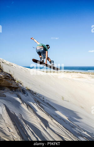 Sandboarder sautant une dune à Ribanceira Beach. Imbituba, Santa Catarina, Brésil. Banque D'Images