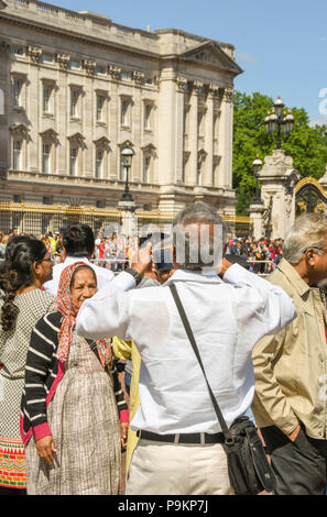 Les touristes de prendre une photo des membres de la famille à l'extérieur de Buckingham Place Banque D'Images