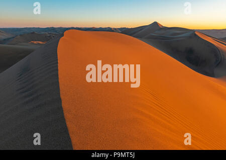 Coucher de soleil dans les dunes de sable du désert situé entre l'Ica et de Huacachina, au Pérou. Banque D'Images