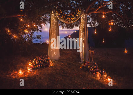 Cérémonie de mariage la nuit avec beaucoup de lumières, des bougies, des lanternes. Belles décorations brillantes romantique au crépuscule Banque D'Images