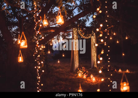 Cérémonie de mariage la nuit avec beaucoup de lumières, des bougies, des lanternes. Belles décorations brillantes romantique au crépuscule Banque D'Images