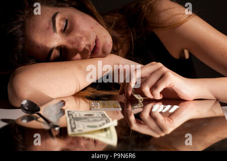 Une jeune femme toxicomane allongé sur le miroir avec de la poudre blanche Banque D'Images