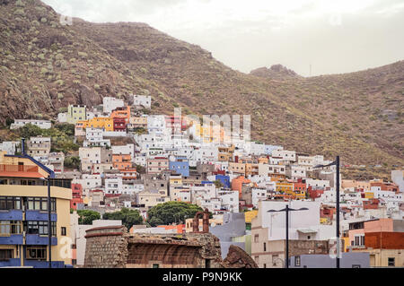 Un village de pêcheurs traditionnel de couleur vive ensemble dans une montagne avec un château en ruine pour la lutte contre les pirates dans l'avant-plan. San Andrés, Tener Banque D'Images