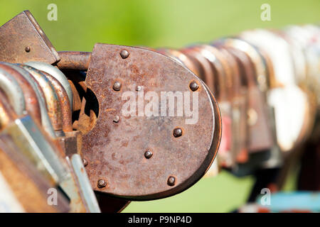 Old rusty metal cadenas avec autres serrures fermées sur la rambarde du pont en rapport avec le mariage, close-up, selective focus Banque D'Images