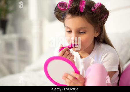 Cute girl mise sur le maquillage. Banque D'Images