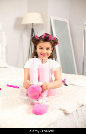 Cute girl putting chaussons sur. Banque D'Images