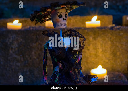La Calavera Catrina doll la nuit entourée de bougies pour le Jour des Morts Mexicain Banque D'Images