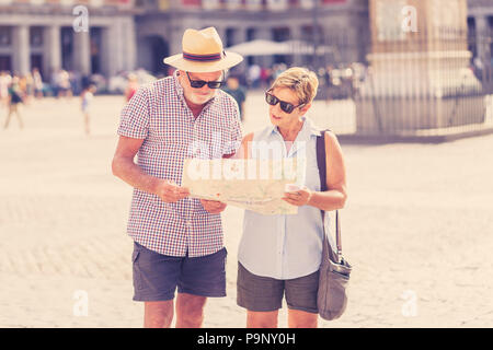 Happy tourist couple retraités actifs à la recherche de leur emplacement dans la Plaza Mayor de Madrid en retraite vacances voyage partout en Europe. Banque D'Images