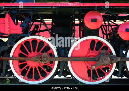 Les trains vintage avec de grandes roues rouges sur les pistes d'une journée ensoleillée Banque D'Images